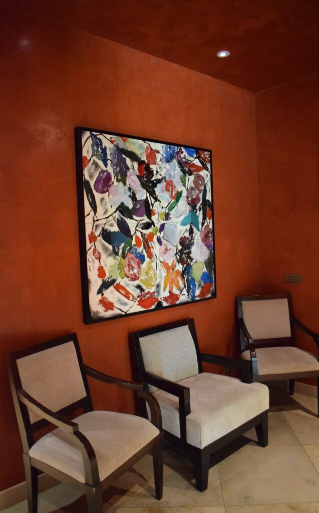Murs et plafond en duit rouge avec 3 fauteuils et une peinture